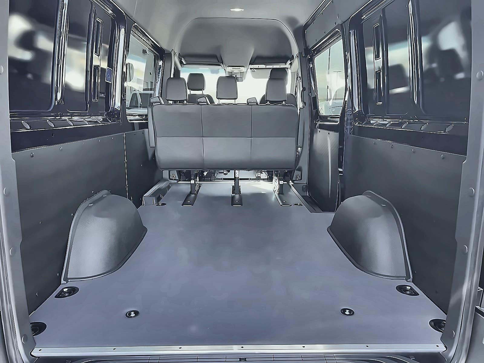 Inside TFSL's Mercedes Sprinter with rear seats removed: the load floor is flat and clear for luggage and a bench row remains